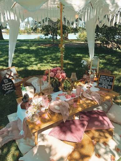 A floral outdoor table setting with cushions and soft linens