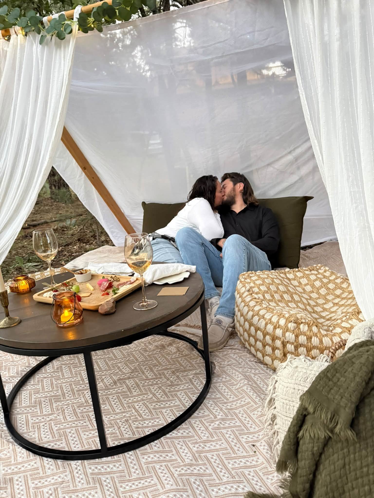 Couple sharing a private picnic beneath a soft draped canopy